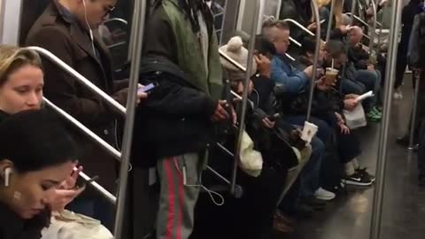 White headphones raps along to music on subway