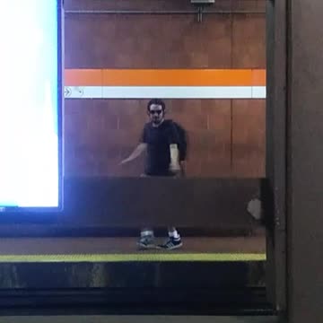 Guy dancing sunglasses headphones across subway station platforms