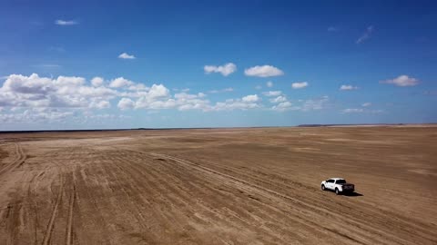 A Pickup Truck Is Travelling On A Desert