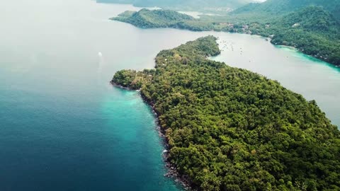 Coastal Serenity: A Tranquil Aerial View of Sea, Stones, and Lush Greenery