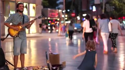 Cute girl dancing in the street to electric guitar