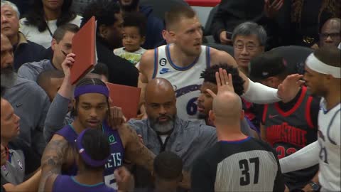 Kristaps Porzingis and Jalen McDaniels get tangled up into the front row