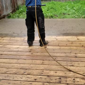 Hard work power washing a deck for stain