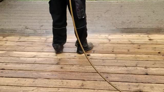 Hard work power washing a deck for stain