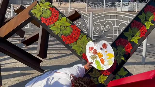 Ukrainian woman hand painting anti-tank hedgehog