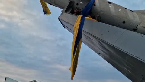 A man hangs a flag from a Soviet-era plane in Bakhmut, Ukraine