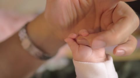 Mother holding hands with her baby