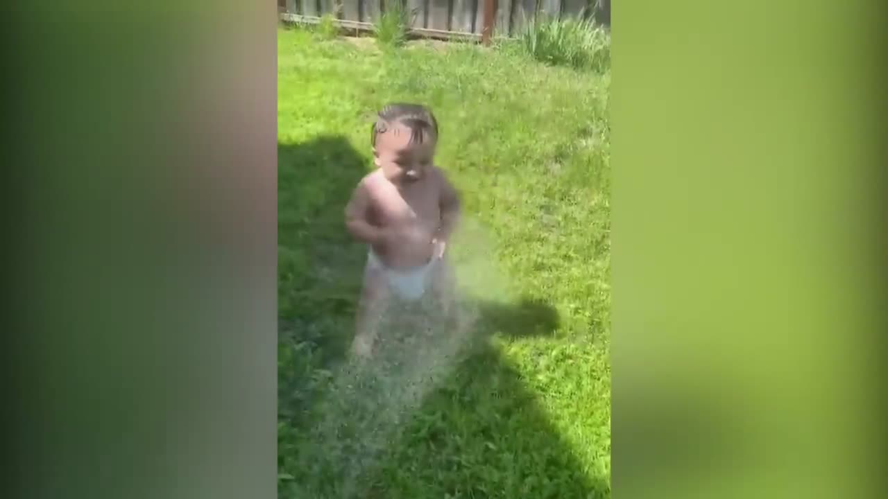 baby loves getting sprayed with the hosepipe, cute and funny