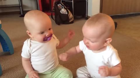 Twin baby girls fight over pacifier