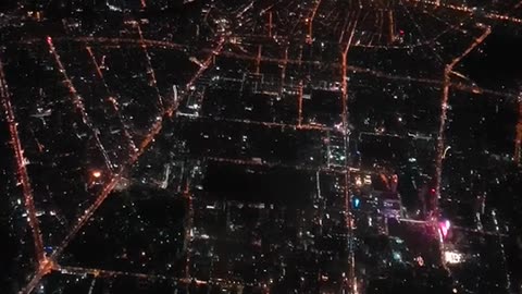 Airplane window view of a city at night