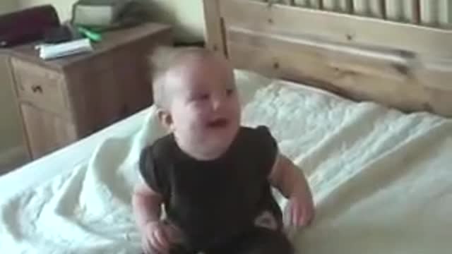 Baby girl laughing while Mom is doing laundry