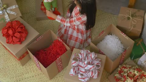 Little girl opening gifts at christmas