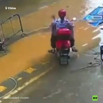 Solo en China: una mujer en moto se hunde al intentar atravesar un charco