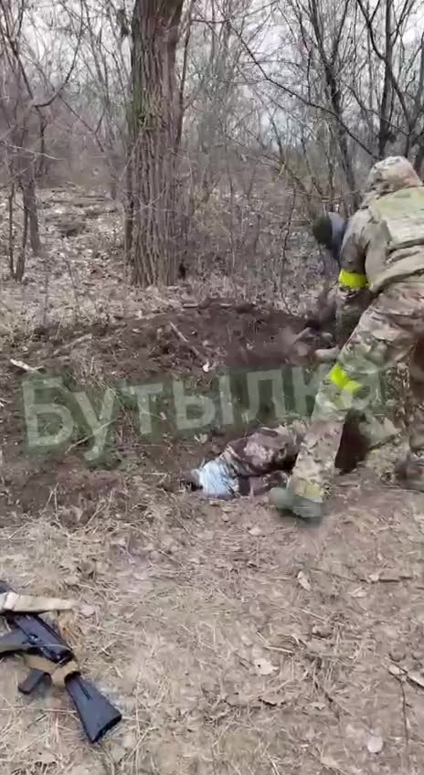 Ukrianian soliders throw comrade into a ditch and start burying him