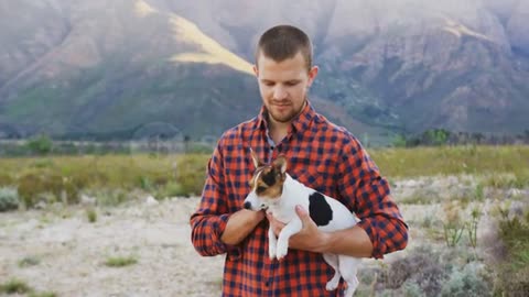 Caucasian man looking at camera with his dog in his arms