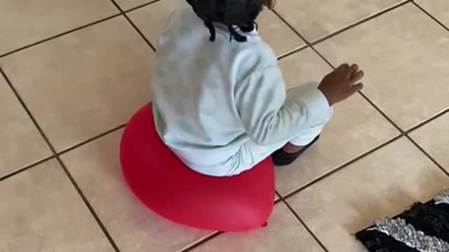 Toddler Using a Balloon as a Chair Pops It