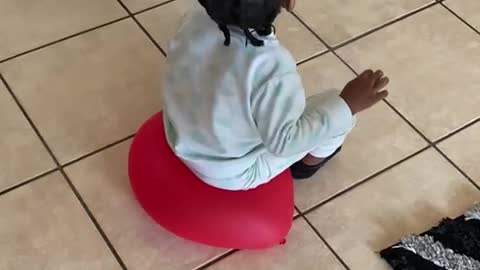 Toddler Using a Balloon as a Chair Pops It