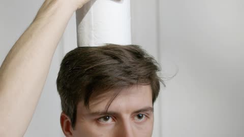 A indian man settleing tissue papers on head