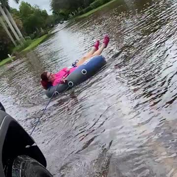 Woman goes tubing in the streets of Florida during Tropical Storm Eta