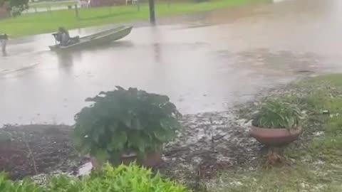 Man Rides his Boat on Flooded Streets of Mississippi During Heavy Rainfall