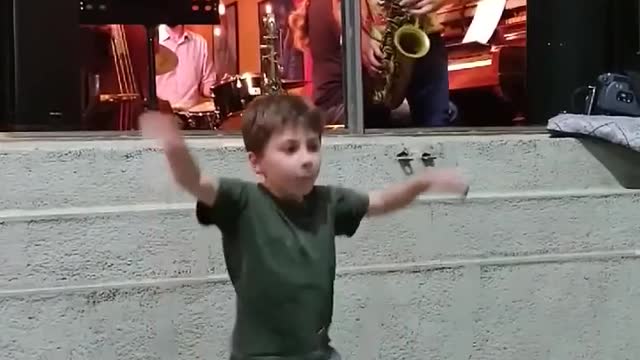 Kid Dances Zestfully While Band Performs At Jazz Bar