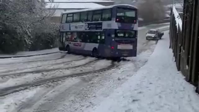 Person Witnesses Bus Drifting Down Snow-Covered Road