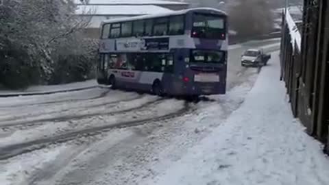 Person Witnesses Bus Drifting Down Snow-Covered Road