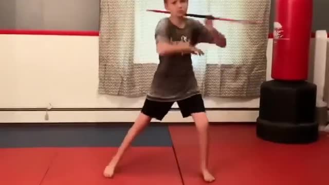 Kid Twirls Bo Staff and Demonstrates Impressive Fighting Routine