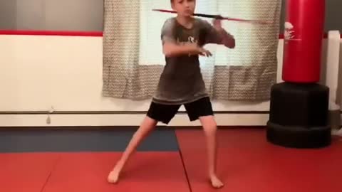 Kid Twirls Bo Staff and Demonstrates Impressive Fighting Routine