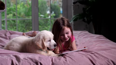 Cute little girl watching videos with her nice dog