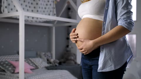 Woman lovingly caressing her pregnant belly