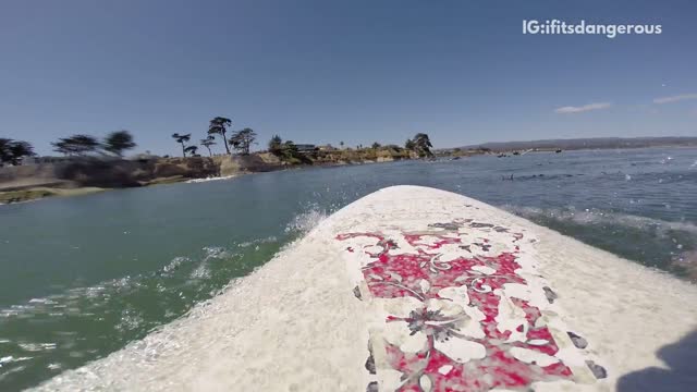 White surfboard guy rides over guy on red surfboard