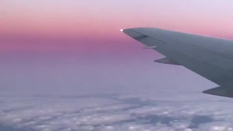 view of airplane wing above clouds