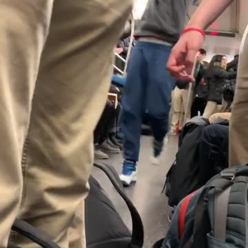 Guy swings and flips on subway train ceiling handrails and slides upside down