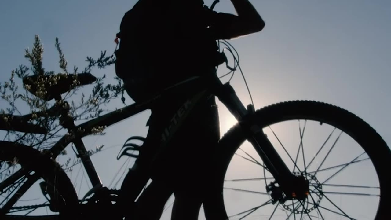 Silhouette in front of the sun of a cyclist outdoors