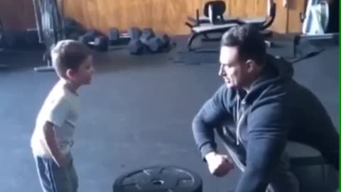 Child learning to lift weights with his feet