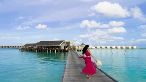 Woman dances in front of an ocean villa