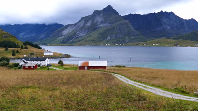 road towards some houses along the lake at fredvang in norway