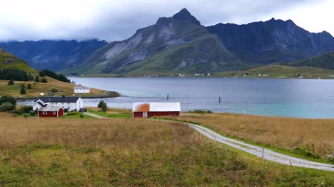 road towards some houses along the lake at fredvang in norway
