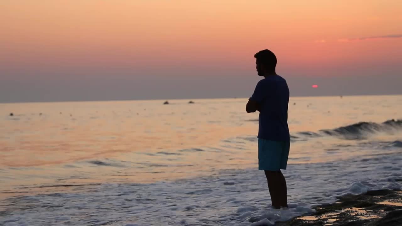 Lonely and brooding man on the shore of a beach