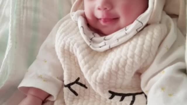 A 73-day-old baby smiling at her mother.