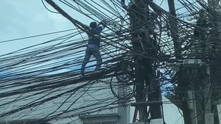 Worker Climbs Along Electric Wires