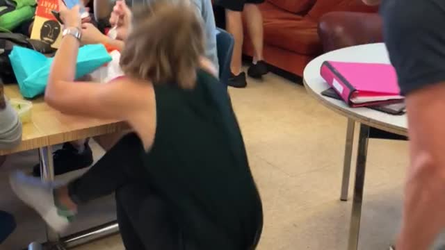 Guy pulls chair from girl sitting falls on floor backpack