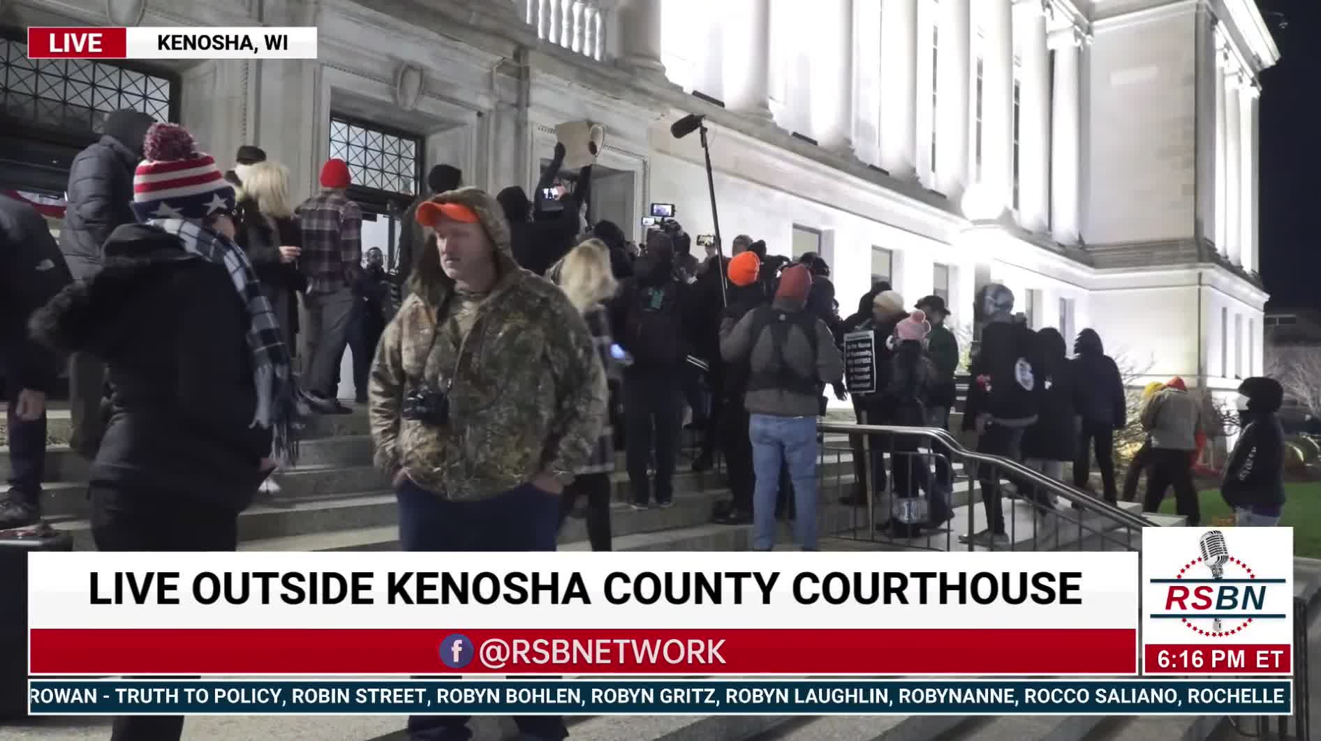 Protesters rip up someone’s sign and throw the pieces at her outside the courthouse in Kenosha