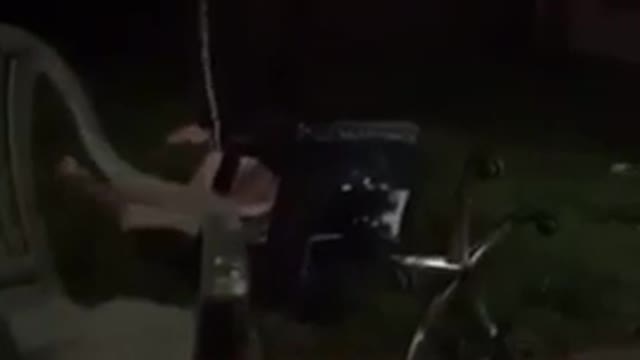 Man in grey jacket rolls back in office chair and dabs while falling down