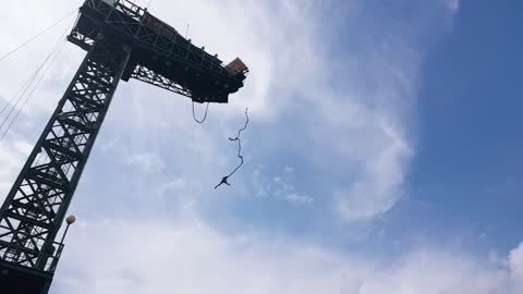 A man who bungee jump on a sunny day.