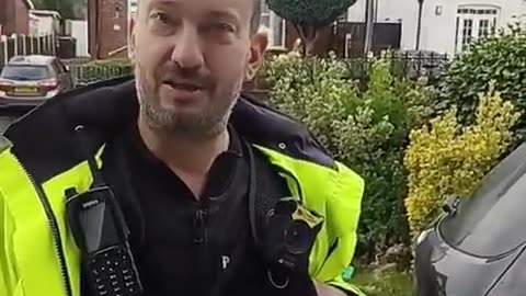 A UK police officer pays a home visit to a man for hanging a PALESTINIAN flag out of his window.