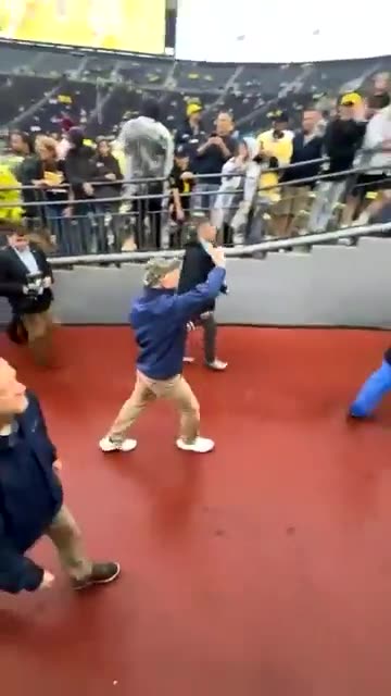 Tim Walz pretends to wave to nonexistent supporters as the crowd screams “TRUMP 2024”