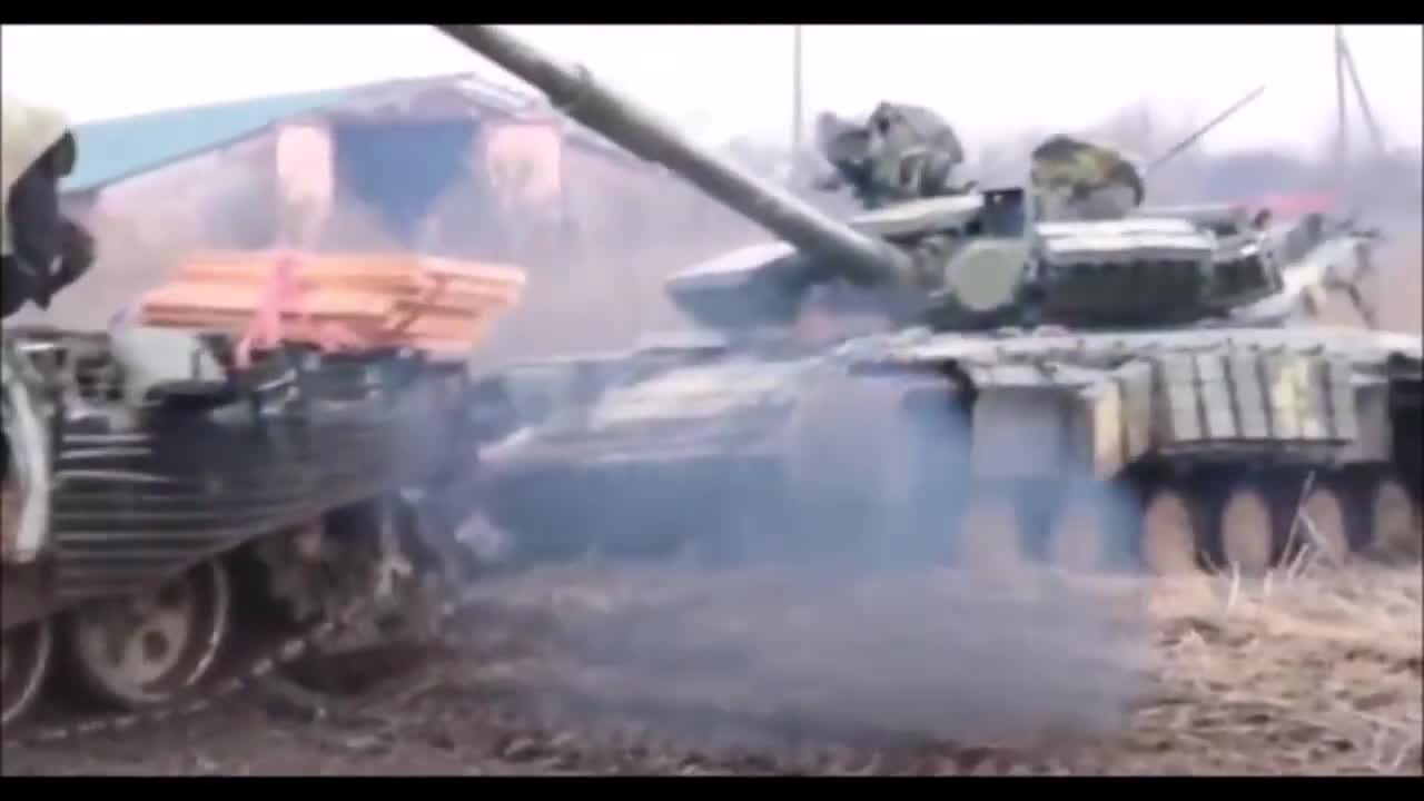 A Russian T-72B3 Tank Pulling A Captured Ukrainian T-64BV Tank.