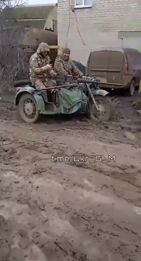 Ukrainian soldiers driving a motorcycle with sidecar, they mounted a machine gun to it